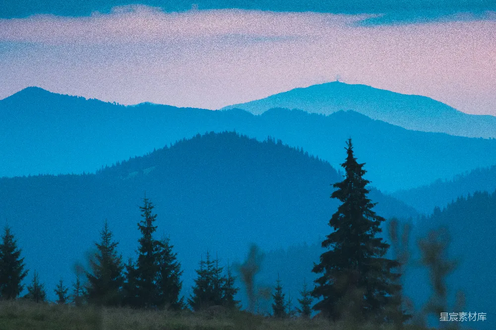 高清摄影  一座山脉的远景，前景中有树木。