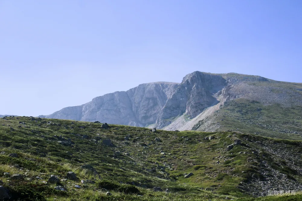 高清摄影  一座山脉，山脚下有一片草地。