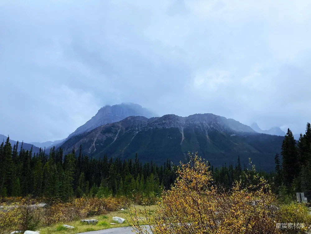 高清摄影 旅行 一幅山峦的风景，前景中有树木。