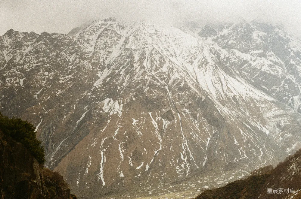 高清摄影  云层低垂，雪山在远处矗立。