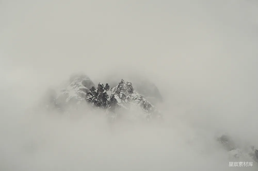 高清摄影  雾中露出积雪覆盖的山峰