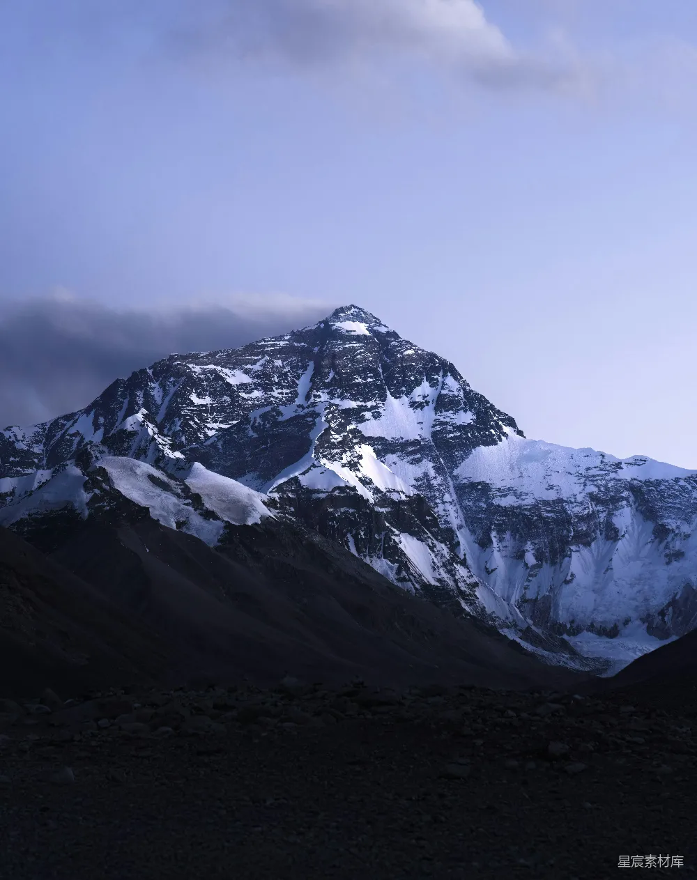 高清摄影  被雪覆盖的山峰，天空中有云层。