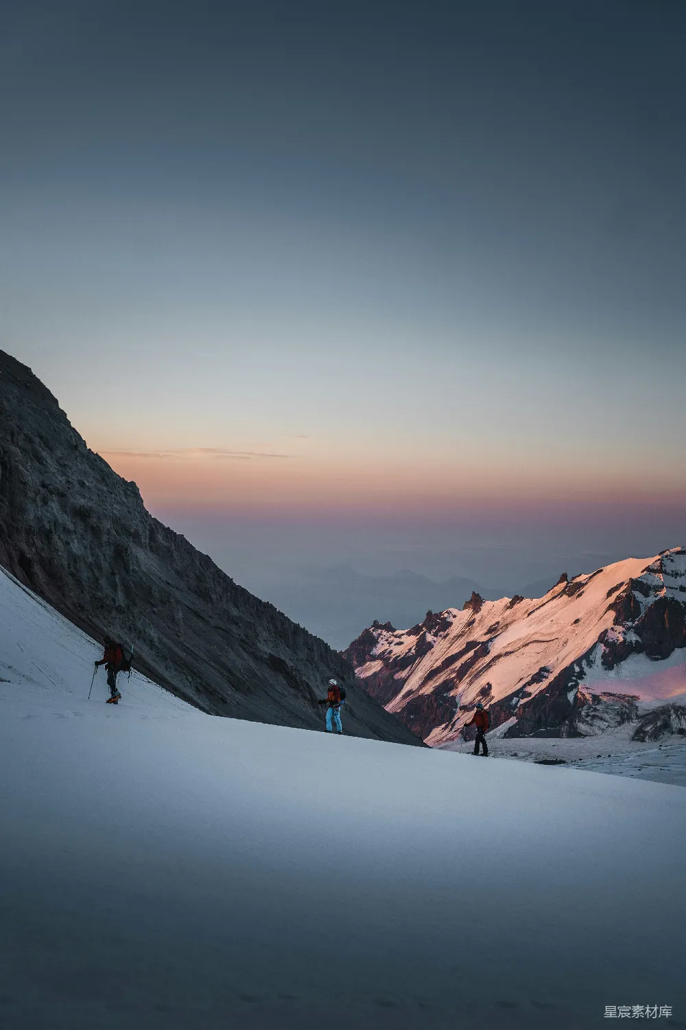 高清摄影 壁纸 旅行 人物 一群人在积雪覆盖的山侧徒步登山。