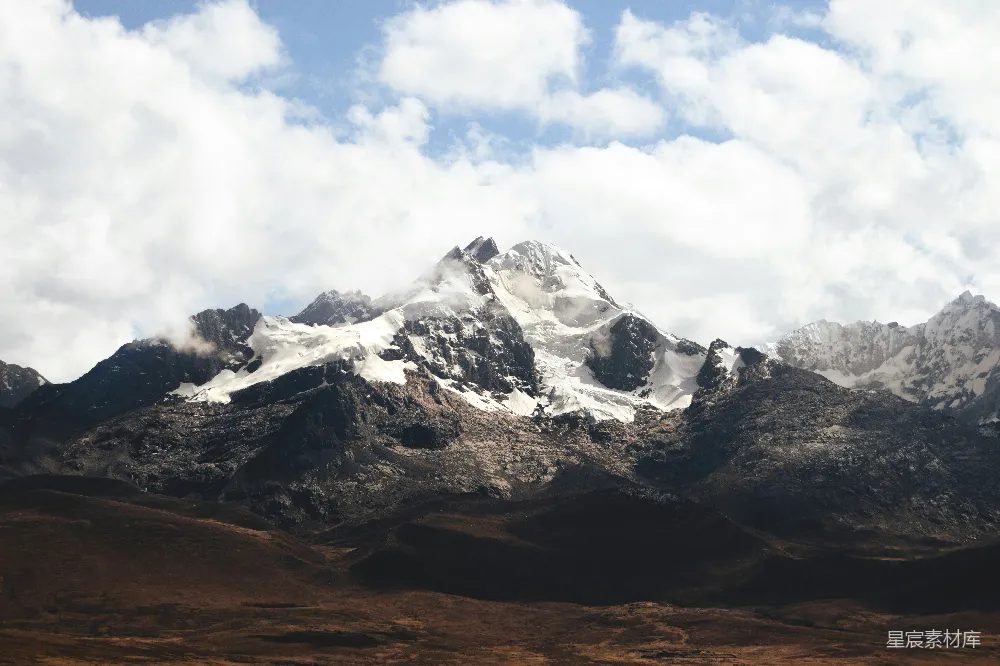 高清摄影  一座山脉，背景中覆盖着积雪的山峰。