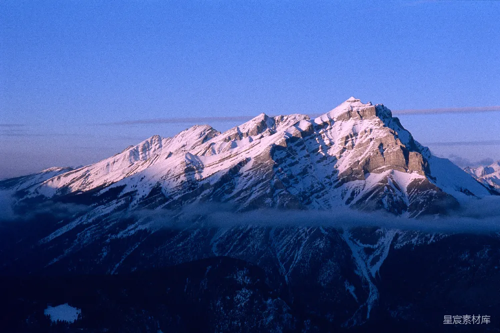 高清摄影  白雪覆盖的山峰在晴朗的蓝天之下。