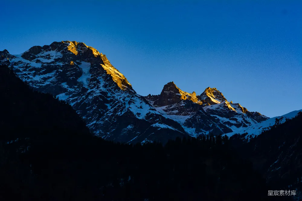 高清摄影  一座被雪覆盖的山，背景是蓝天。