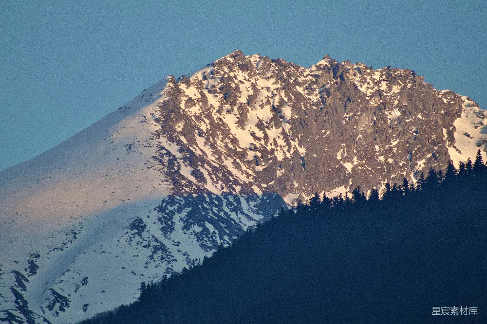 高清摄影  被金色的夕阳照亮的积雪覆盖的山峰。