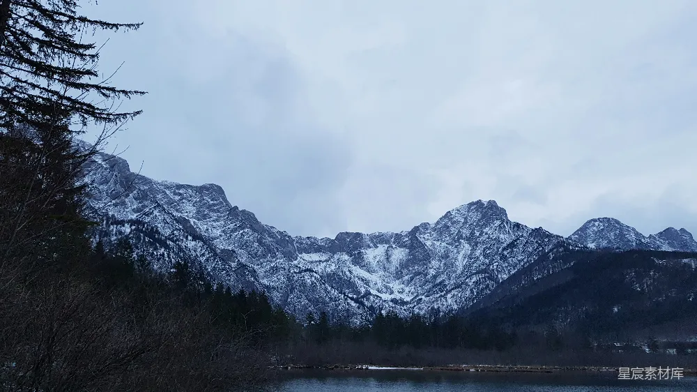 高清摄影  白天水边覆盖着积雪的山
