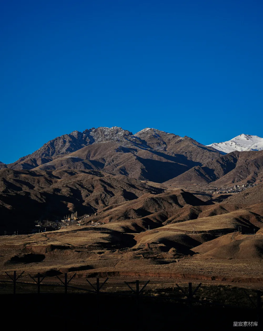高清摄影  一座山脉，背景中是被白雪覆盖的山峰。
