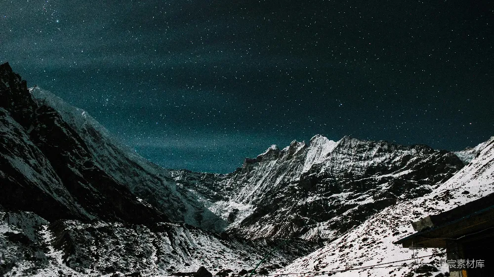 高清摄影  覆盖着雪的山峰，前景中有一座房子。