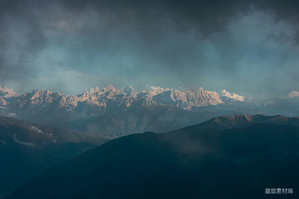 高清摄影  雄伟的雪山在云层密布的天空下。
