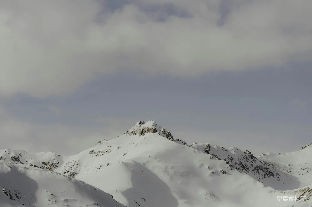 高清摄影 自然 一座被白雪覆盖的山峰在多云的天空下