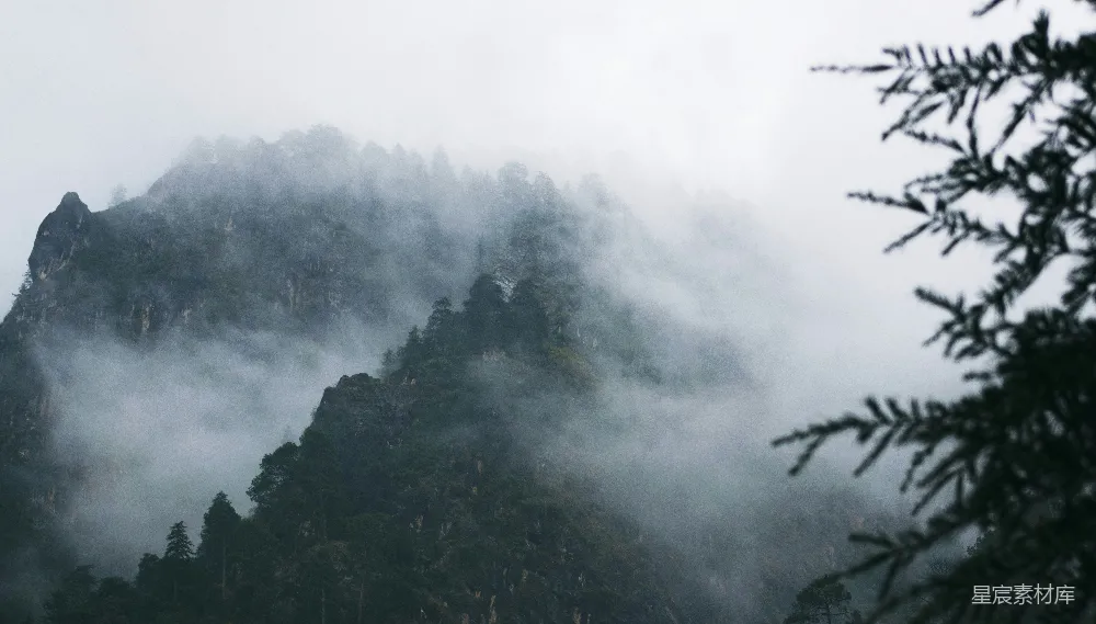 高清摄影  一座非常高大的山峰，被雾和云笼罩着。