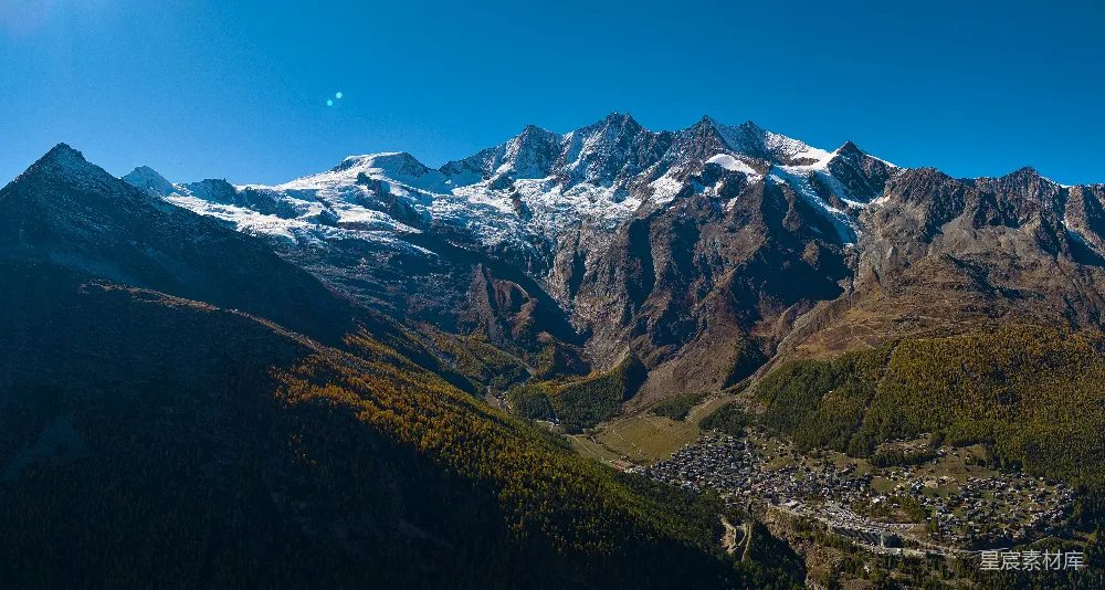 高清摄影  雄伟的雪山俯瞰着山下的村庄。