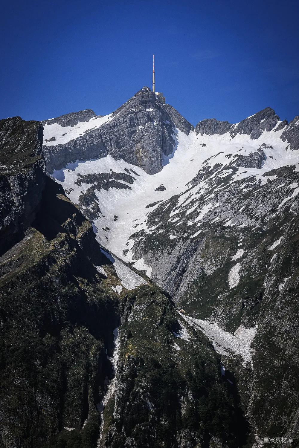 高清摄影  雪山顶峰在蓝天下的通信塔。