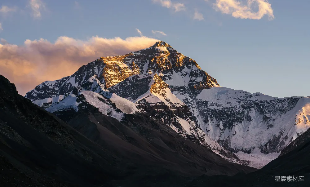 高清摄影  被雪覆盖的山峰，天空中有云。