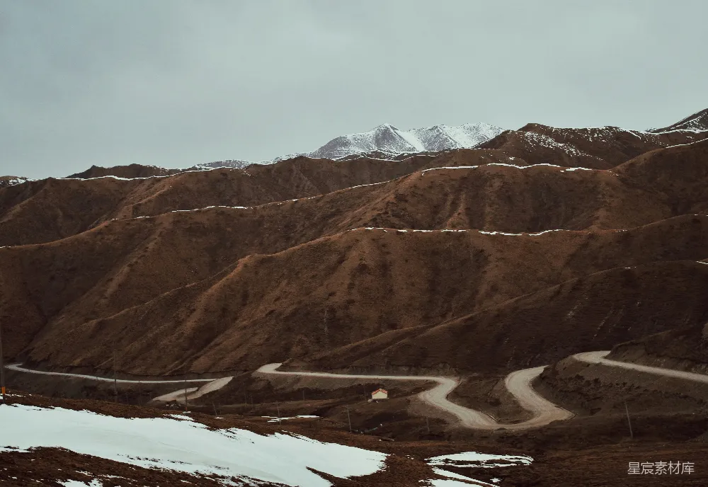 高清摄影  一条蜿蜒的山路，地上覆盖着积雪。