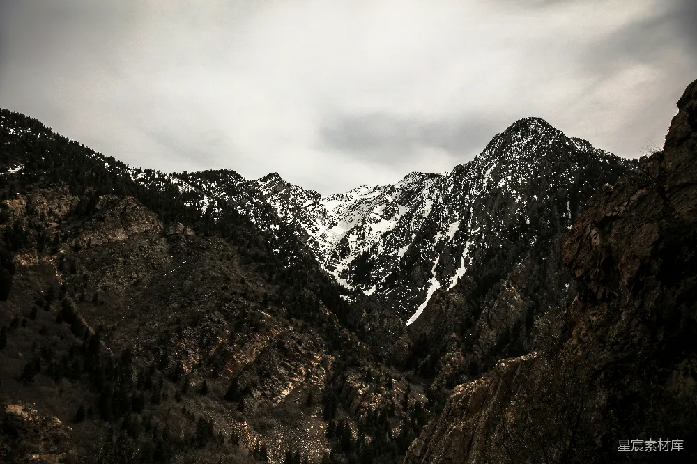 高清摄影  雪覆盖的山峰上方多云的天空