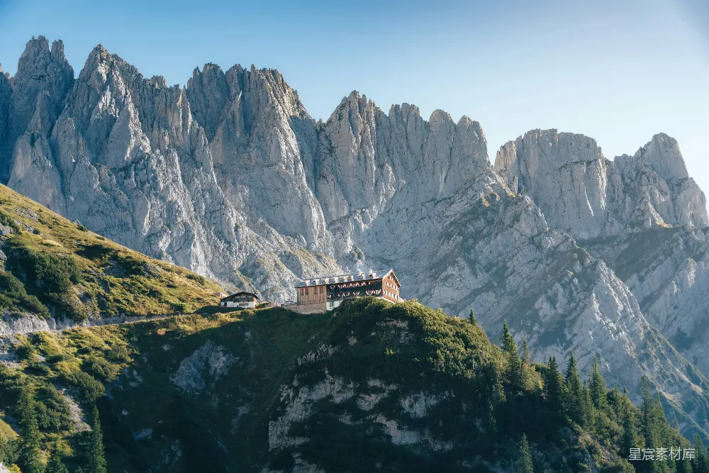 高清摄影 壁纸 山间小屋坐落在绿坡之上，周围是尖峭的山峰。
