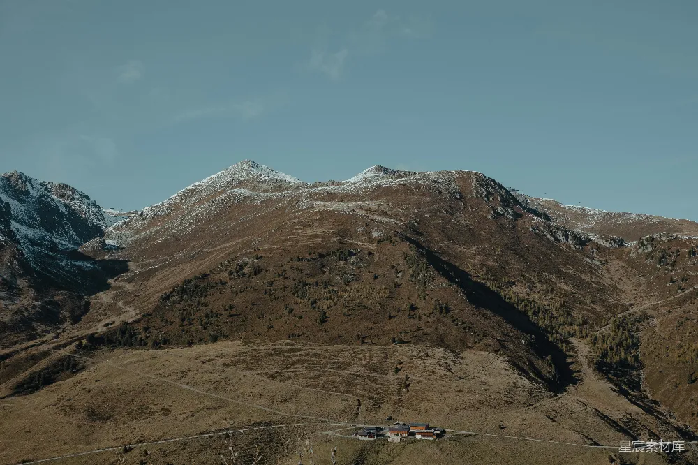 高清摄影  一座山峰的远景，前景中有座房子。