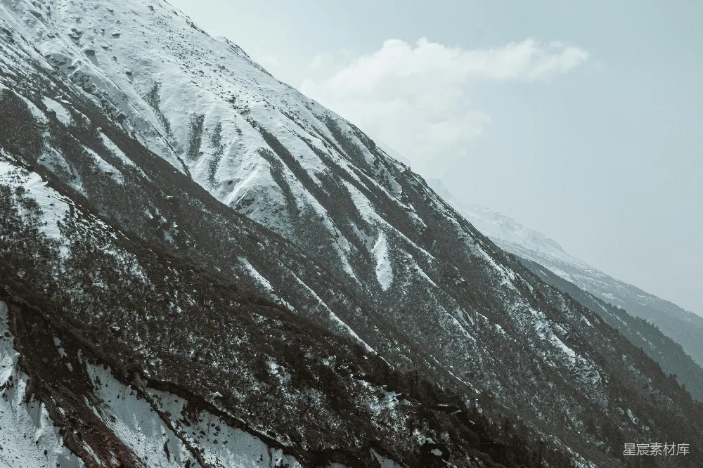 高清摄影  被云层覆盖的积雪山坡