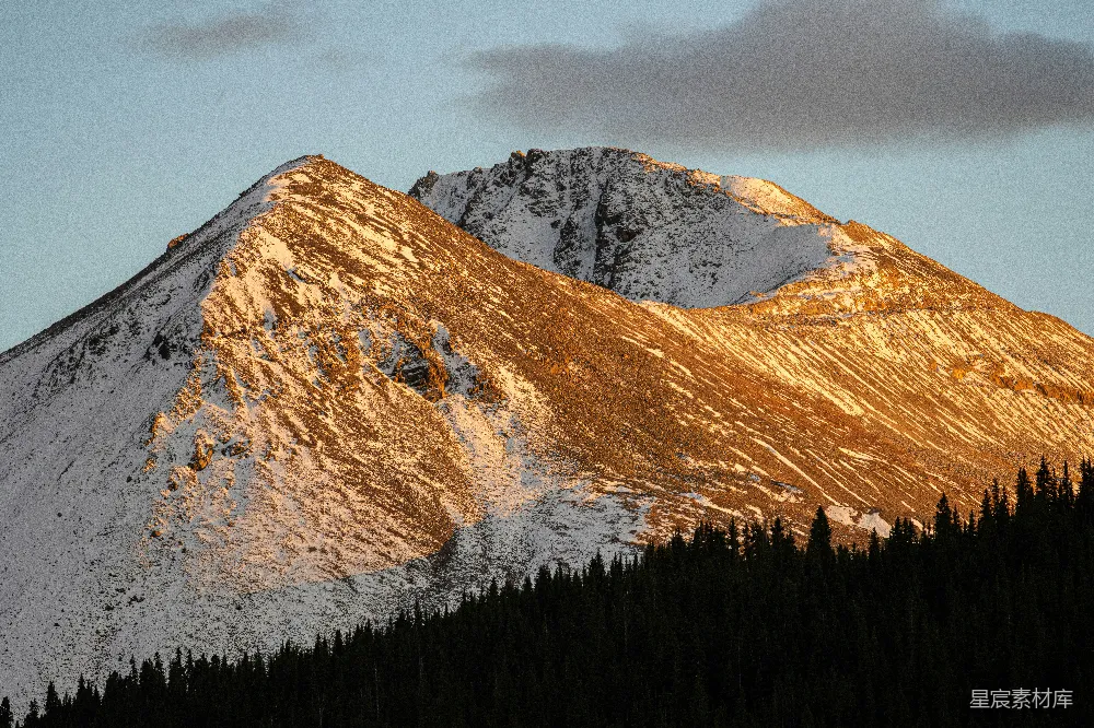 高清摄影 自然 一座覆盖着积雪的山峰，山脚下有树木。