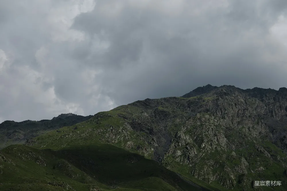 高清摄影 壁纸 自然 一座山峰，背景是阴云密布的天空。