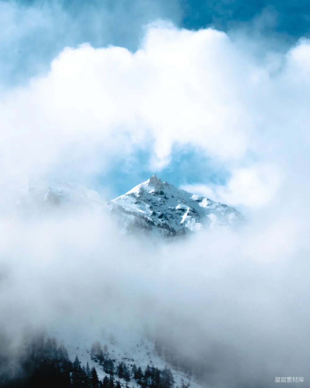 高清摄影  白天云层覆盖下的白雪皑皑的山峰