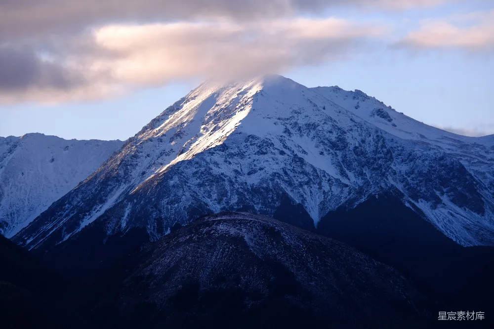 高清摄影  雪山峰顶部分被云层和阳光覆盖。