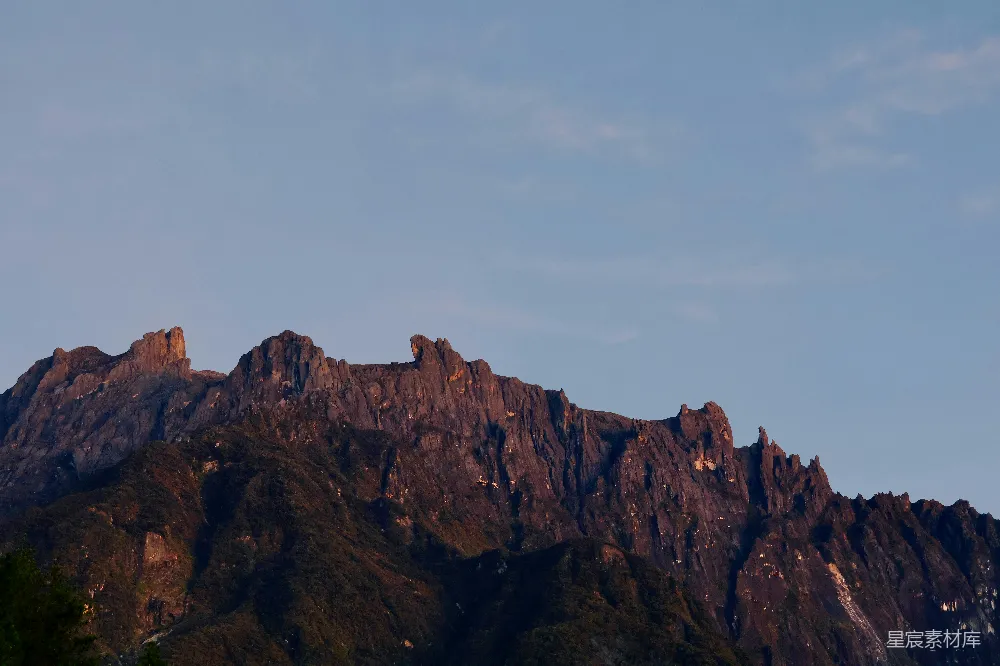 高清摄影  崎岖的山峰沐浴在温暖的夕阳光辉下。
