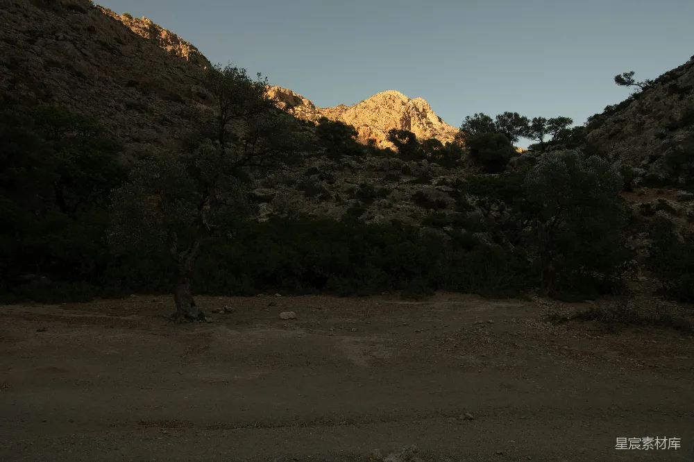 高清摄影  夕阳正在落向一座岩石山。