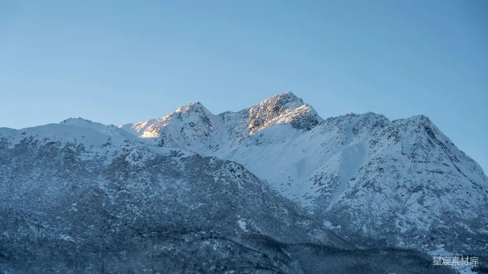 高清摄影 自然 被积雪覆盖的山峰，背景是蓝天。