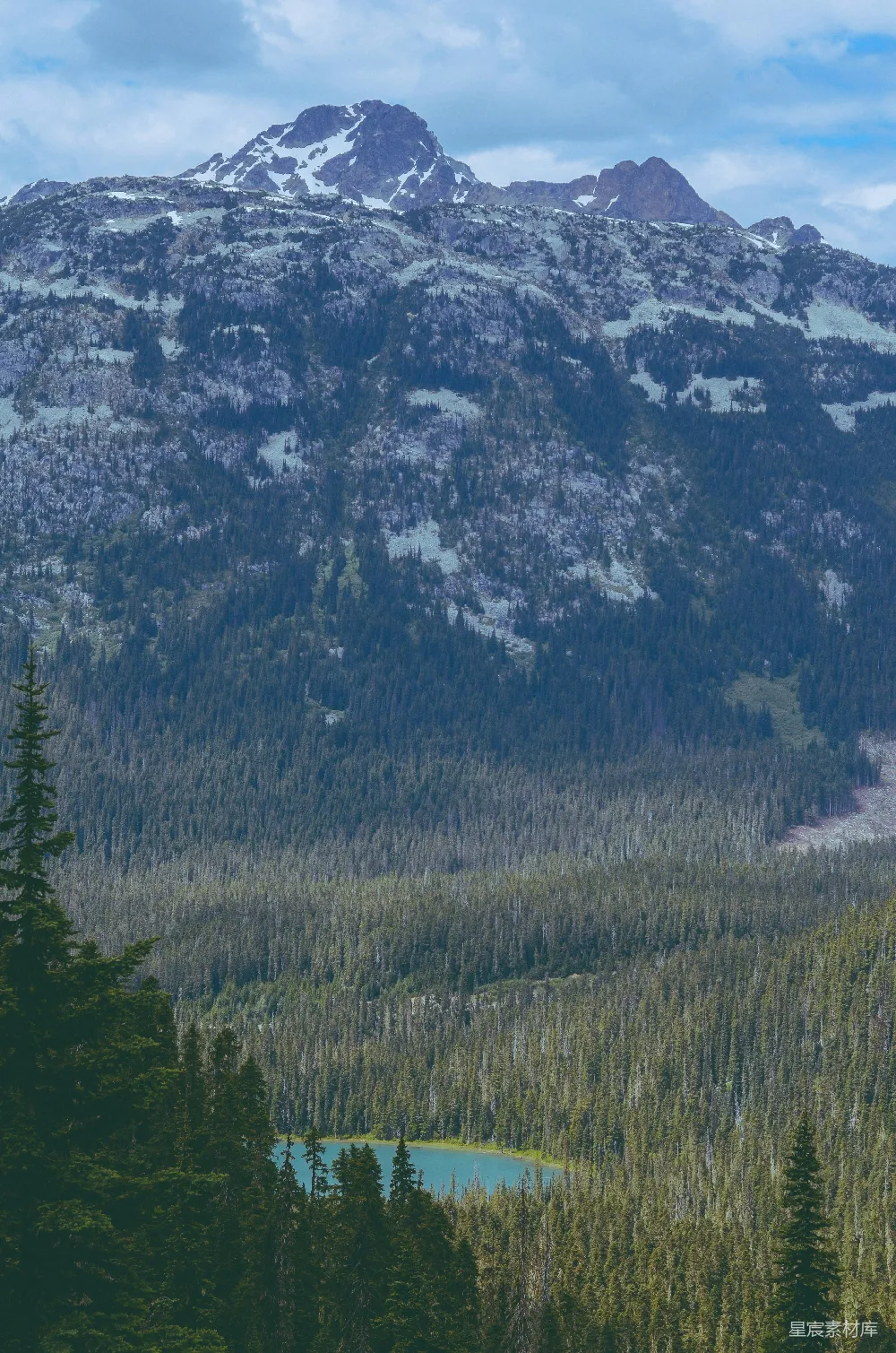 高清摄影  一座山脉的远景，前景中有一片湖泊。