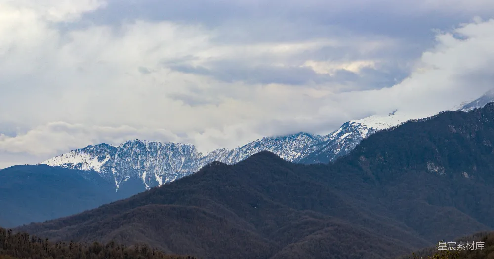 高清摄影  白天阴云密布下的积雪覆盖的山峰