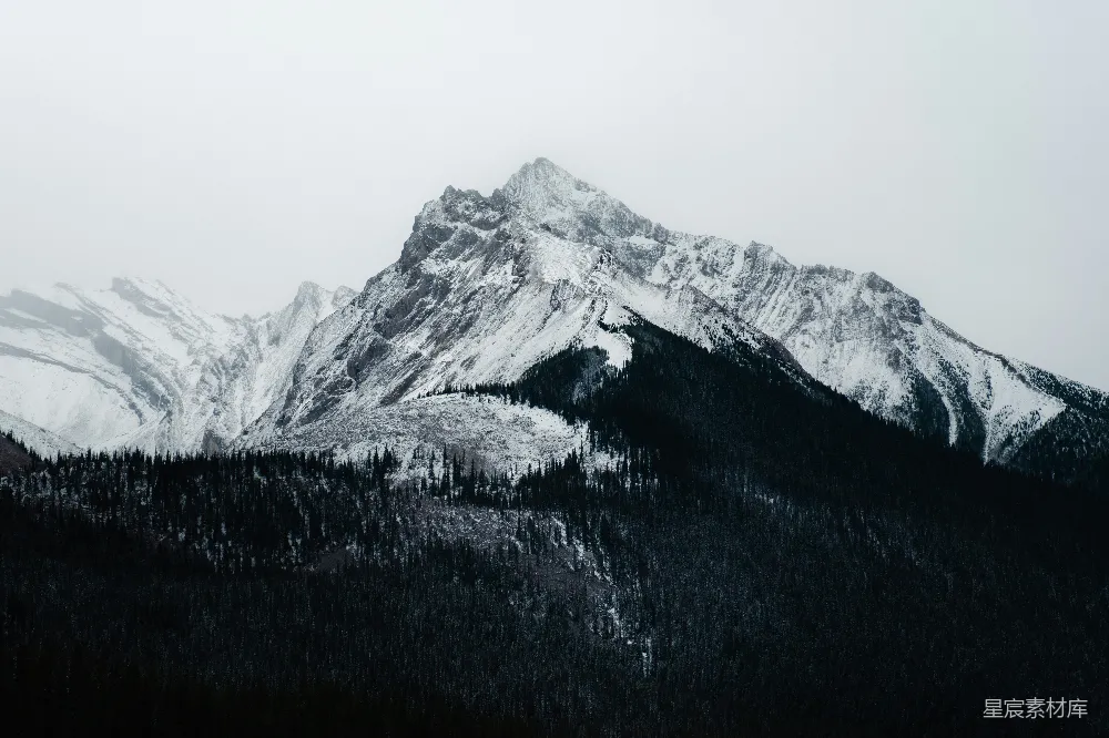 高清摄影  云层密布的天空下覆盖着积雪的山峰