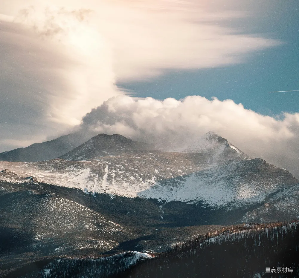 高清摄影  一座被雪覆盖的山峰，天空中有云。
