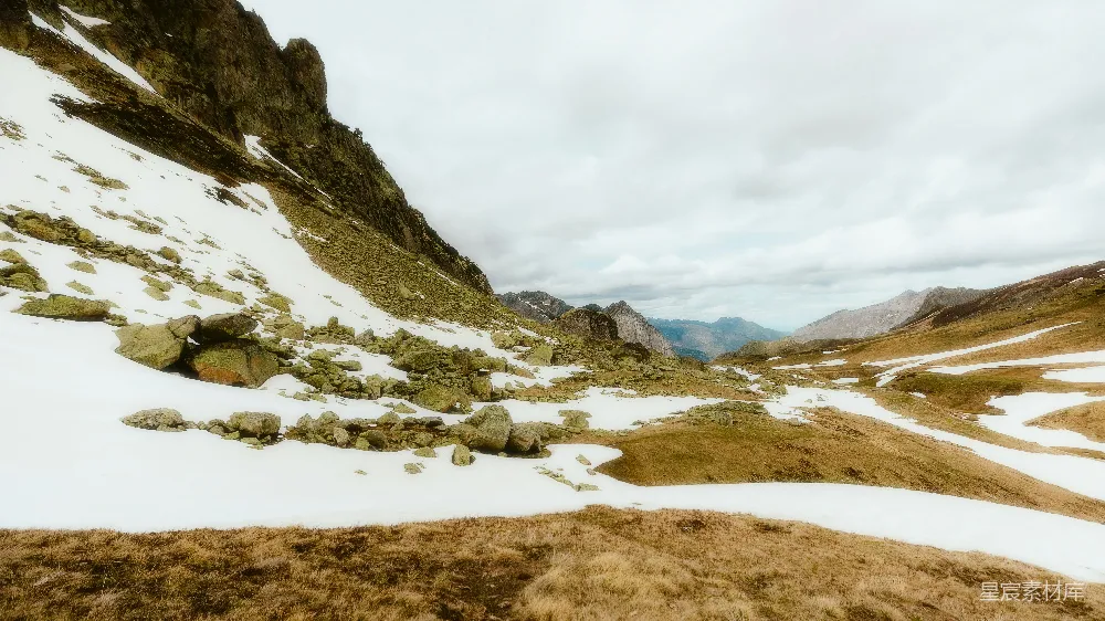 高清摄影  被雪覆盖的山丘，上面有岩石和草地