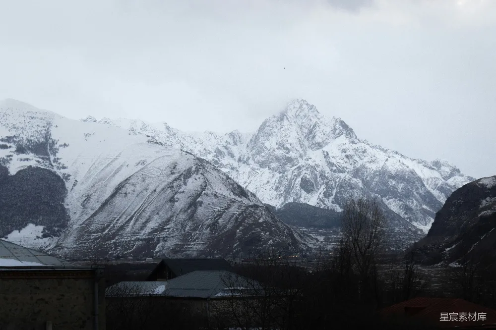高清摄影 旅行 自然 壁纸 一座被雪覆盖的山脉，前景中有房屋。