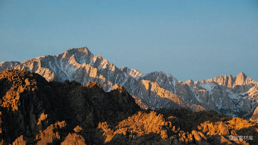 高清摄影  一座山脉，背景是白雪覆盖的山峰。