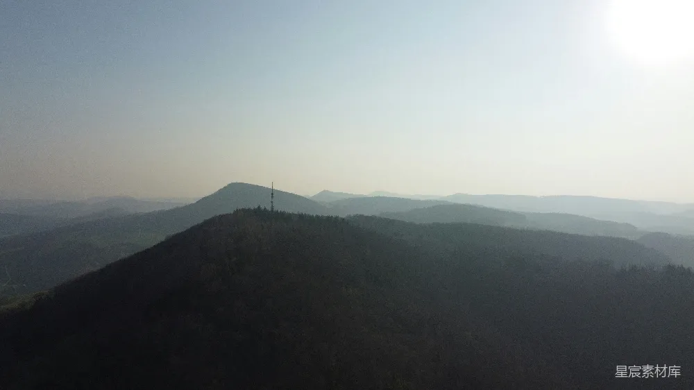 高清摄影  一幅风景画，有山丘和一座塔楼。