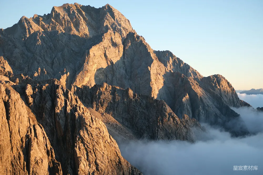 高清摄影  陡峭的山峰在云层之上沐浴在温暖的阳光之中