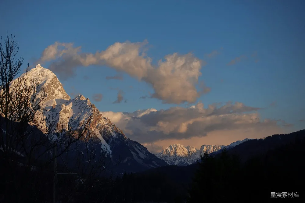 高清摄影  雪山峰顶被金色夕阳照亮。