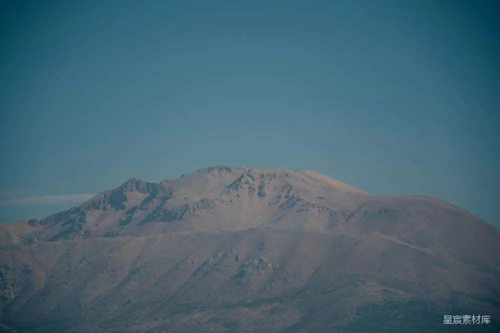 高清摄影  一座覆盖着雪的山脉，背景是蓝天。
