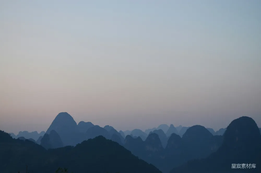 高清摄影  白天在灰蒙蒙的天空下，山的轮廓显现。