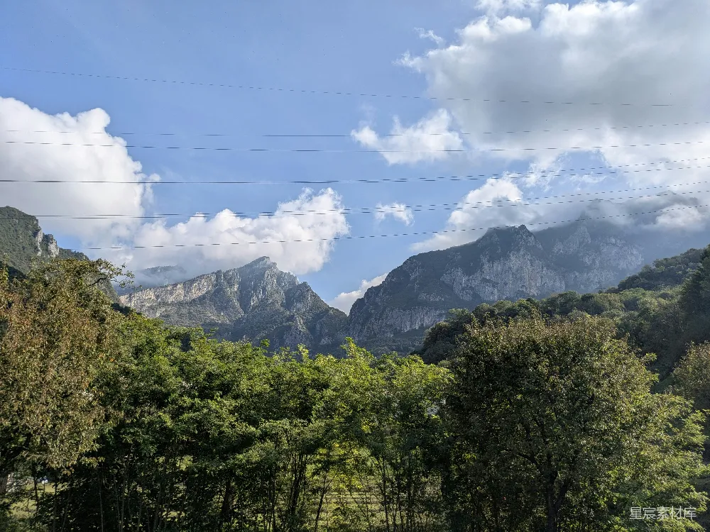 高清摄影 旅行 自然 郁郁葱葱的树木矗立在雄伟的山峰前。