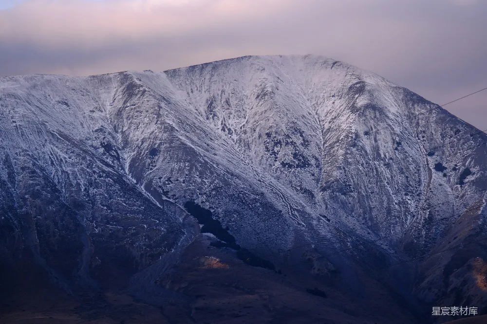 高清摄影  一座巍峨的雪山在云层下。