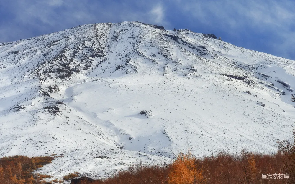高清摄影 壁纸 自然 一座被雪覆盖的高山，前景中有树木。