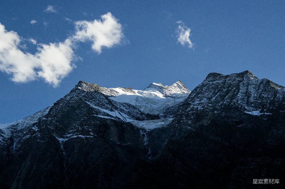 高清摄影  覆盖着雪的山峰，天空中有一朵云。