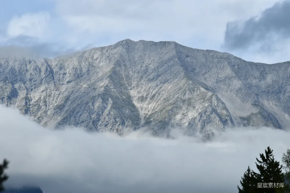 高清摄影  巍峨的山峰从翻滚的云层中矗立而出