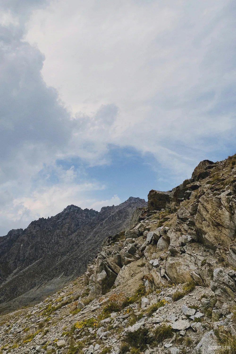 高清摄影  岩石覆盖的山坡，背景中有山。